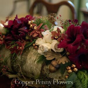 birch log with amaryllis, orchids, and roses