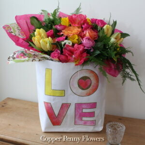 Love Blooms Bouquet is bright spring bouquet in reusable paper bag