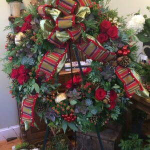holiday evergreen wreath decorated with roses, succulents, berries, opulent bow