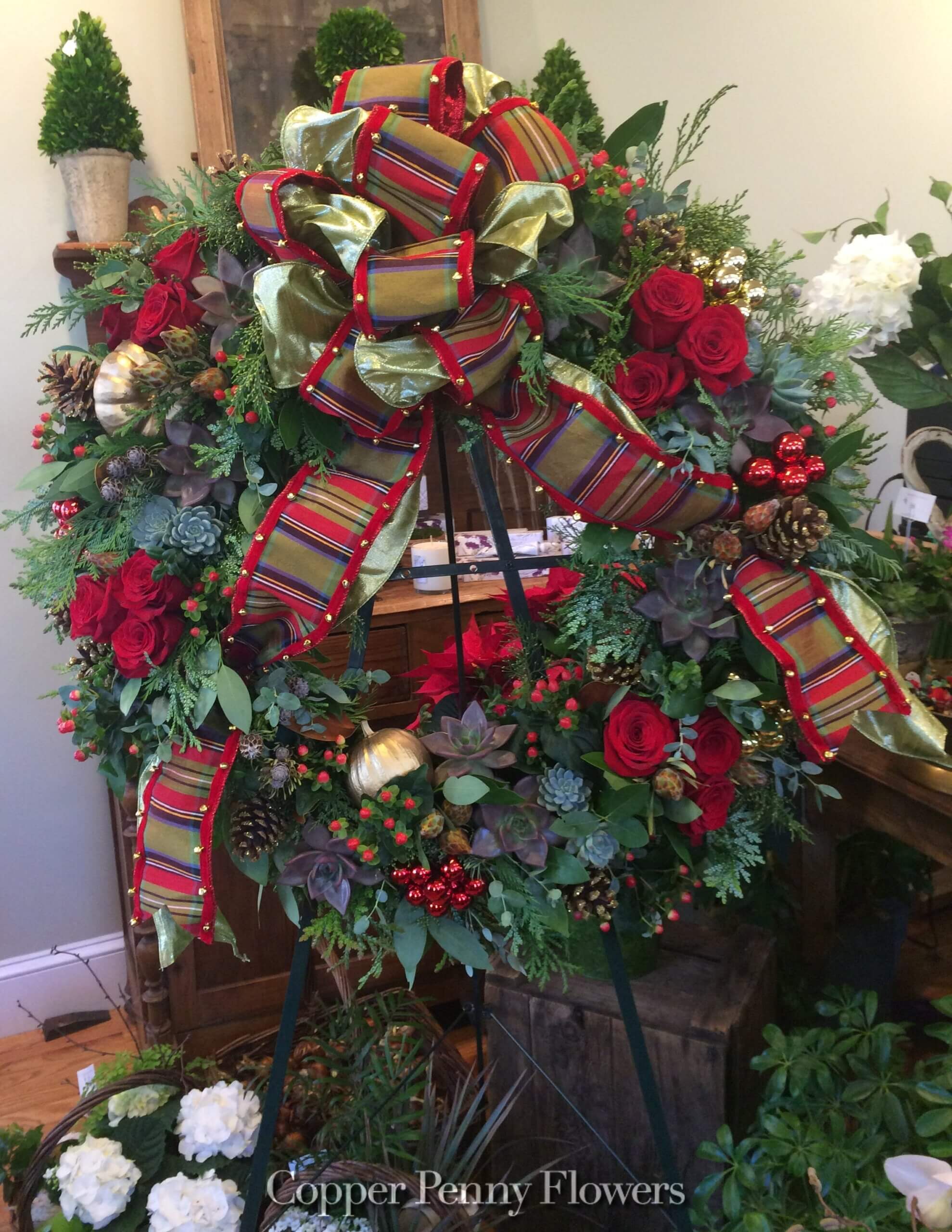 holiday evergreen wreath decorated with roses, succulents, berries, opulent bow