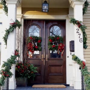 double front doors with festive everygreen wreaths and garland decorationss