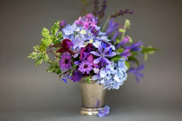 Hues from blue to violet to magenta. We visit the cool end of the spectrum with blue hydrangea, exotic agapanthus, lavender, corn flowers and stock arranged in a keepsake mint julep cup.