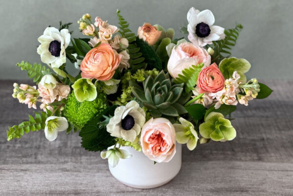 Amy's Plenty Pretty features peach and green blooms with white anemone in a white container