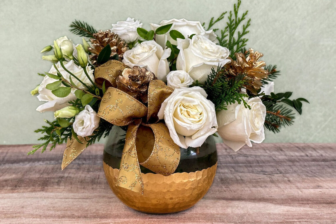 Golden Song is a flower arrangement featuring white blooms with a gold bow in a golden and glass bowl