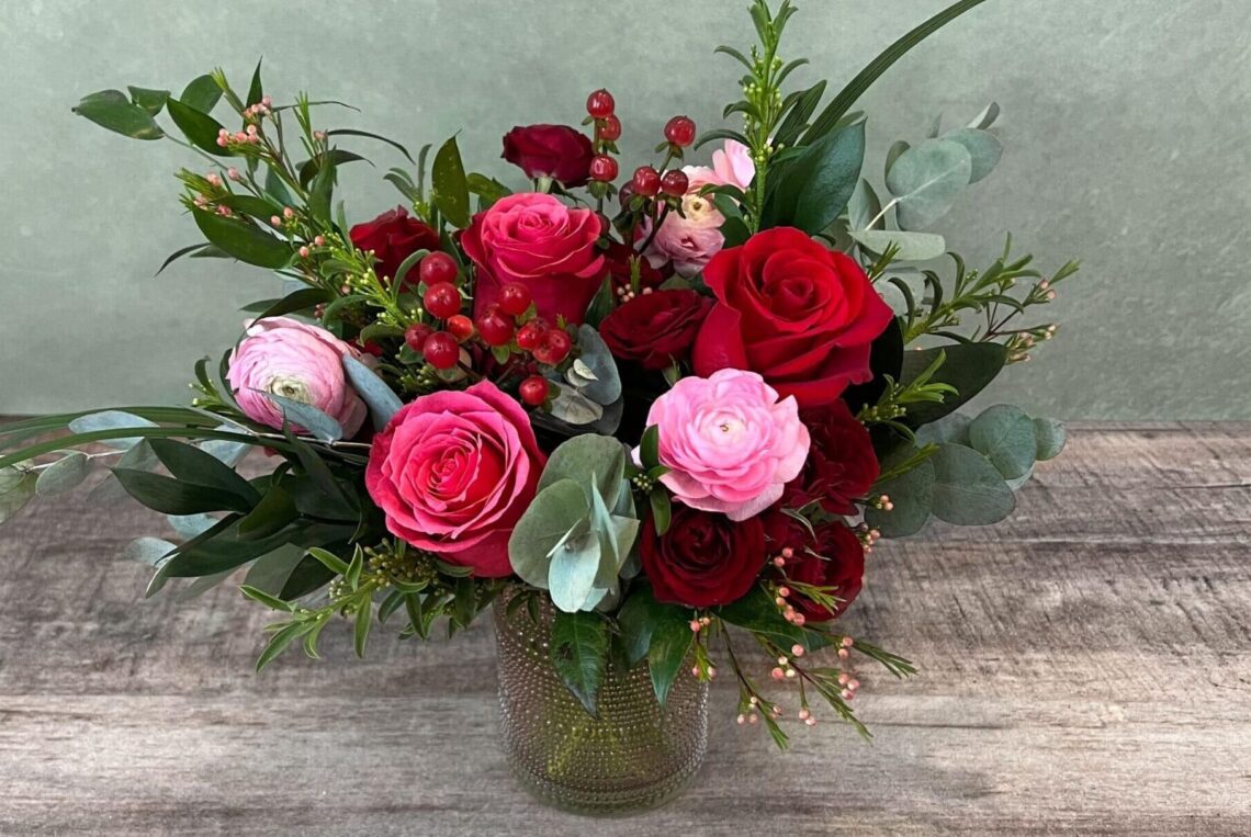 Lovesent is red, hot pink, and light pink roses with premium greens in a glass vase