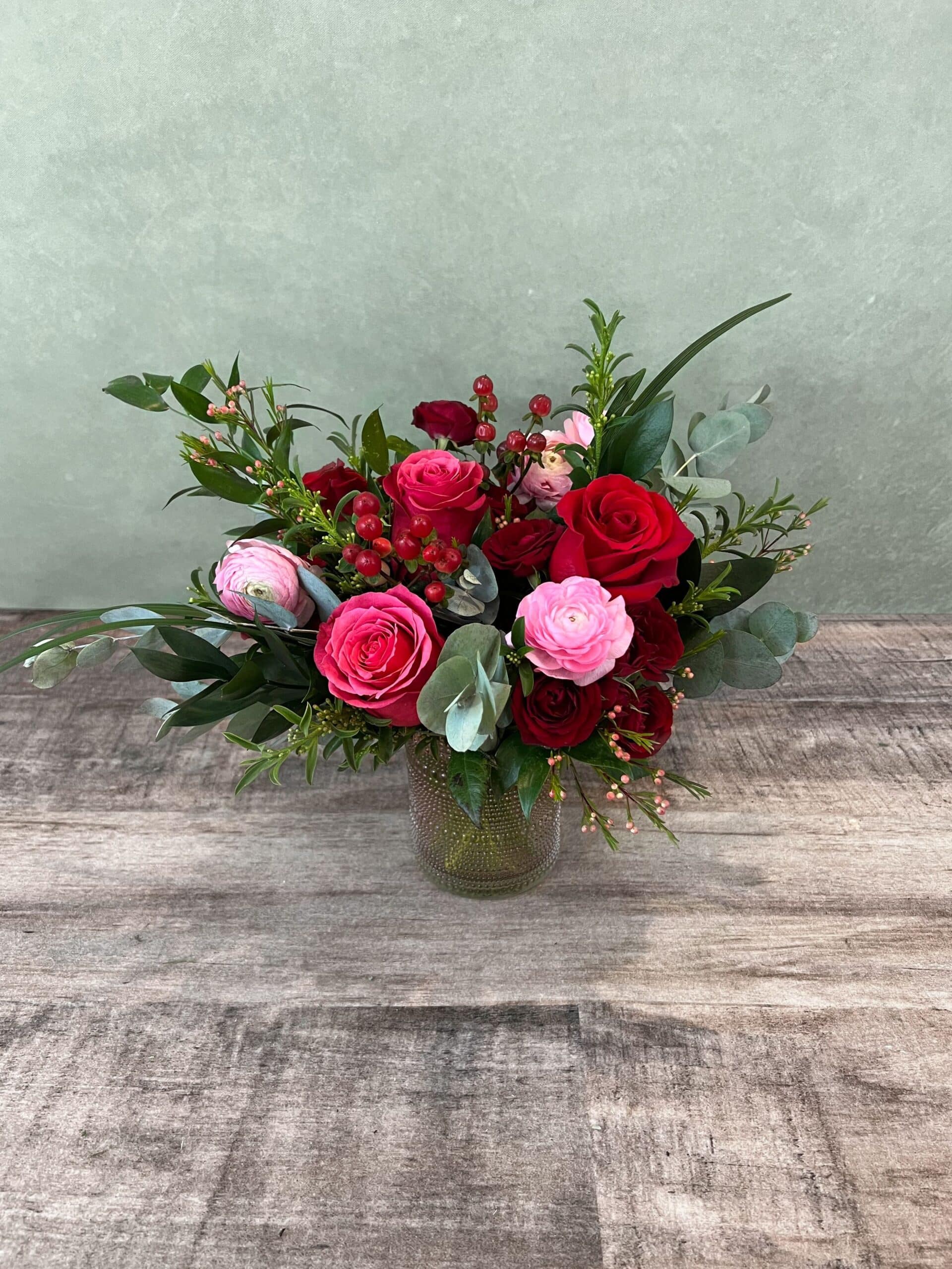 Lovesent is red, hot pink, and light pink roses with premium greens in a glass vase