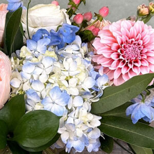 Peach Heaven features peach and blue blooms in a glass vase