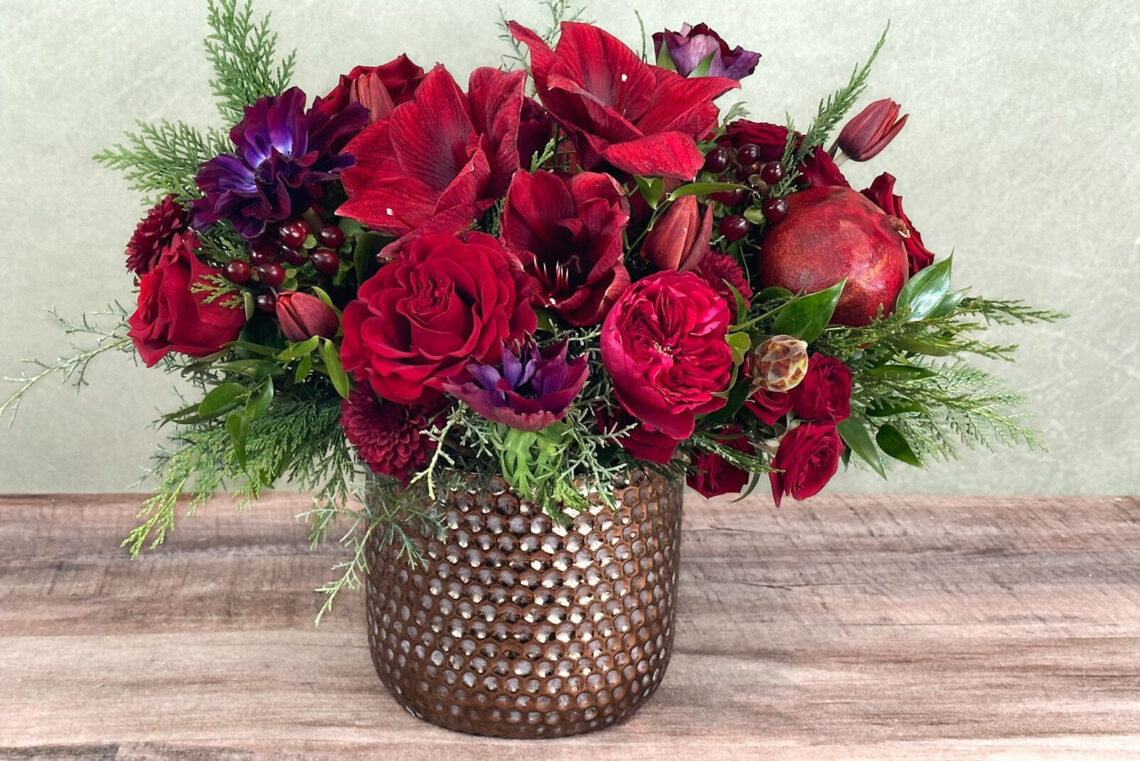 Ruby Park is a mix of crimson and deep violet premium flowers in a coppery keepsake container